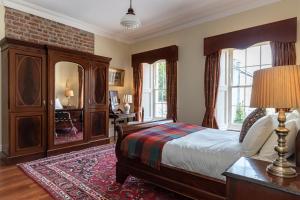 a bedroom with a bed and a dresser and windows at 8 bedroomed house steeped in history in Droíchead an Chláir
