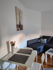 a living room with a table and a couch at Apartman Hugo in Novi Sad
