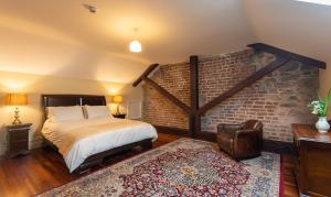 een slaapkamer met een bed en een bakstenen muur bij Beautifully restored soldier's barracks to sleep 10 people in Droíchead an Chláir +16 foto's