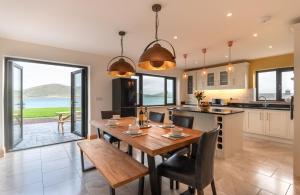 een keuken en eetkamer met een tafel en stoelen bij Luxury 4 bedroom holiday home overlooking the sea on Valentia Island in Knights Town