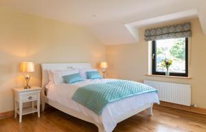 a bedroom with a large white bed with a window at Luxury 4 bedroom holiday home overlooking the sea on Valentia Island in Knights Town