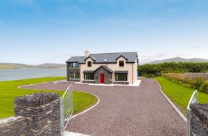 a house with a red door and a driveway at Luxury 4 bedroom holiday home overlooking the sea on Valentia Island in Knights Town