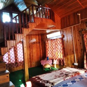 1 dormitorio con escalera y 1 cama en una habitación en Neora valley eco hut's Kolakham, en Lava