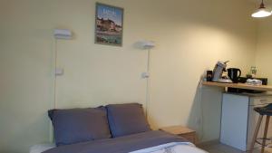 a bedroom with a bed and two lights on the wall at Bonvallet - Studio paisible et chaleureux avec balcon in Amiens