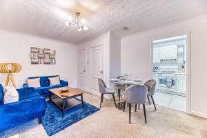 a living room with a blue couch and a table at Cosy 2 Bedroom Flat Chester in Chester
