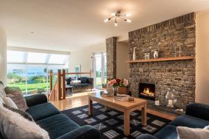 - un salon avec une cheminée en pierre dans l'établissement A split-level spacious home with sea & mountain views, à Templenoe