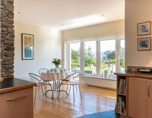 cocina y comedor con mesa y sillas en A split-level spacious home with sea & mountain views, en Templenoe