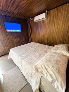 um quarto com uma cama e uma televisão na parede em Cabana Vista Bela em São Salvador