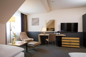 Pokój hotelowy z biurkiem i łóżkiem w obiekcie Lindner Hotel Frankfurt Hochst, part of JdV by Hyatt w Frankfurcie nad Menem