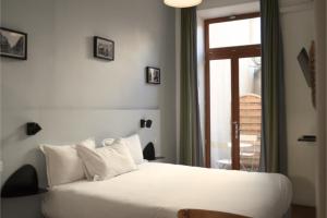 a bedroom with a white bed and a window at Hôtel Saint Louis - Vieux Port in Marseille