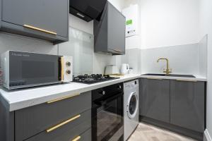 a kitchen with a stove top oven next to a dishwasher at Coatbridge Apartment in Coatbridge