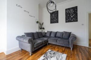 a living room with a gray couch in a room at Coatbridge Apartment in Coatbridge