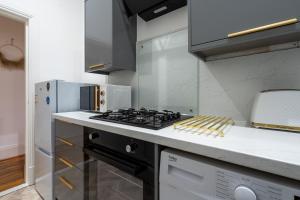 a kitchen with a stove top oven next to a refrigerator at Coatbridge Apartment in Coatbridge