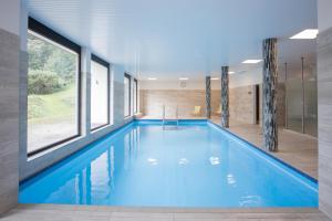 a swimming pool with blue water in a house at Deluxe Apartment - Sauna & Pool - Free Parking in Winterberg