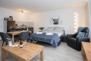 a living room with a bed and a table at Deluxe Apartment - Sauna & Pool - Free Parking in Winterberg