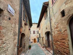 um beco numa cidade velha com edifícios de pedra em Casa Giulia, il gioiello del Borgo em Certaldo