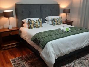 Un dormitorio con una cama con dos animales de peluche encima. en La Casa Guest House, en Bloemfontein