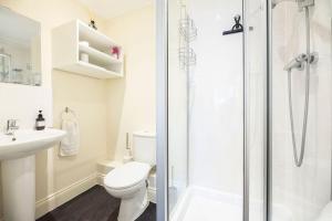 a bathroom with a shower and a toilet and a sink at Fromus Rise, Saxmundham in Saxmundham