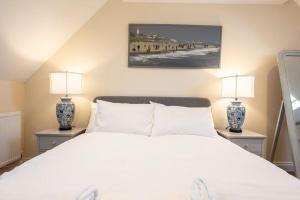 a bedroom with a white bed and two lamps at Fromus Rise, Saxmundham in Saxmundham