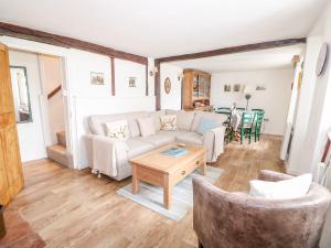 a living room with a couch and a table at Beach Cottage in Holt