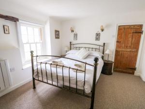 a bedroom with a bed and a wooden door at Beach Cottage in Holt