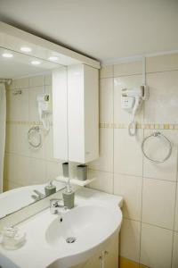 a bathroom with a white sink and a mirror at YARD- Family retreat in Kórinthos