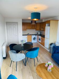 uma cozinha e sala de jantar com mesa e cadeiras em Apartment 2 @ Clifden Bay Apartments em Clifden