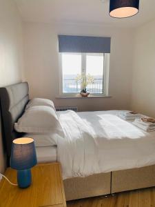 a bedroom with a large white bed and a window at Apartment 2 @ Clifden Bay Apartments in Clifden