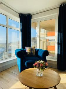 a living room with a blue couch and a table at Apartment 2 @ Clifden Bay Apartments in Clifden