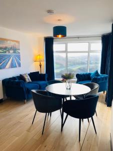 a living room with a table and a blue couch at Apartment 2 @ Clifden Bay Apartments in Clifden