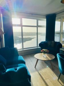 a living room with two blue couches and a table at Apartment 2 @ Clifden Bay Apartments in Clifden