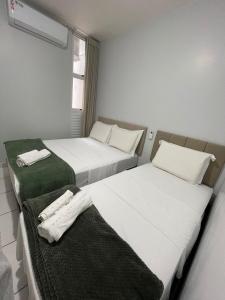 Dos camas en una habitación de hotel con toallas. en Condomínio Colina, en Palmas