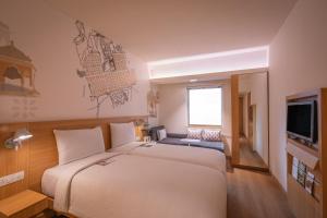 斋浦尔ibis Jaipur City Centre - An Accor Brand的配有一张大床和一台电视的酒店房间