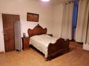 - une chambre avec un lit en bois et une porte en bois dans l'établissement mas cevenol, à Rosières