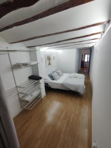 sypialnia z łóżkiem i półkami w pokoju w obiekcie EL RINCÓN deMANUELA w mieście Requena