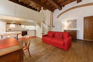 a living room with a red couch and a kitchen at Lambertesca Loft in Florence