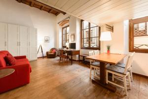 a living room with a table and a red couch at Lambertesca Loft in Florence