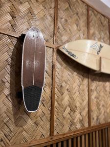 a surfboard hanging on a wall next to a surfboard at Sunny Terrace in Baler