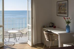 a room with a balcony with a view of the ocean at Cas’ A Mare - Beachfront Luxury Suites in Salerno