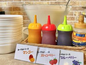 Akashi Castle Hotel - Vacation STAY 83574 في أكاشي: طاولة مع صحون وصحون وسلة مع زجاجات ملونة