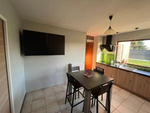 uma sala de jantar com mesa e cadeiras e uma cozinha em Maison Gognies Chaussée 