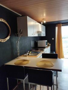 uma cozinha com uma ilha com duas cadeiras e um balcão em Gîte du Cheval Blanc à Houmont em Sainte-Ode
