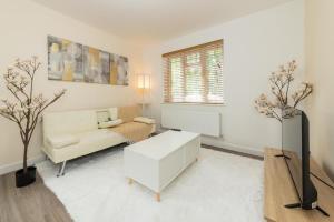 a white living room with a couch and a table at 2Bedroom Flat Freeparking in Reading