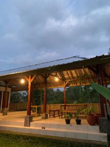 een houten paviljoen met een picknicktafel en banken bij Farmer homestay in Tetebatu