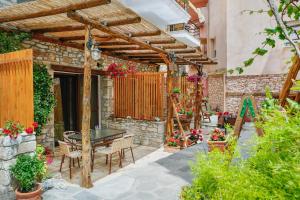 a patio with a table and chairs under a wooden pergola at Thassos Neorion in Limenaria