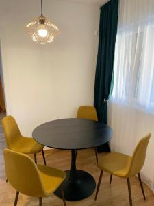 - une table à manger avec des chaises, une table et une lampe dans l'établissement Apartman Jovanov Dvor, à Bijeljina