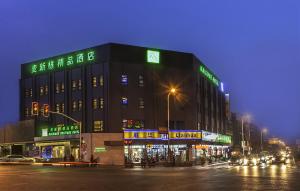 上海麦新格精品酒店（上海国际旅游度假区川沙地铁站店）的街道边有 ⁇ 虹灯标志的建筑物