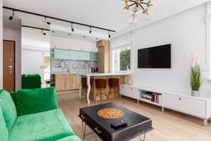 sala de estar con sofá verde y mesa en Leśna Deluxe Apartment en Gdynia