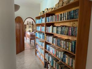 una biblioteca con estanterías de madera llenas de libros en Sal & Lala Castle watamu, en Watamu