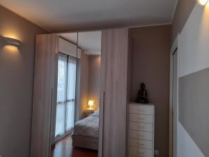 Schlafzimmer mit einem Bett, einer Kommode und einem Spiegel in der Unterkunft Elegant and modern Apartment "Le Fontane" Moncalieri in Moncalieri